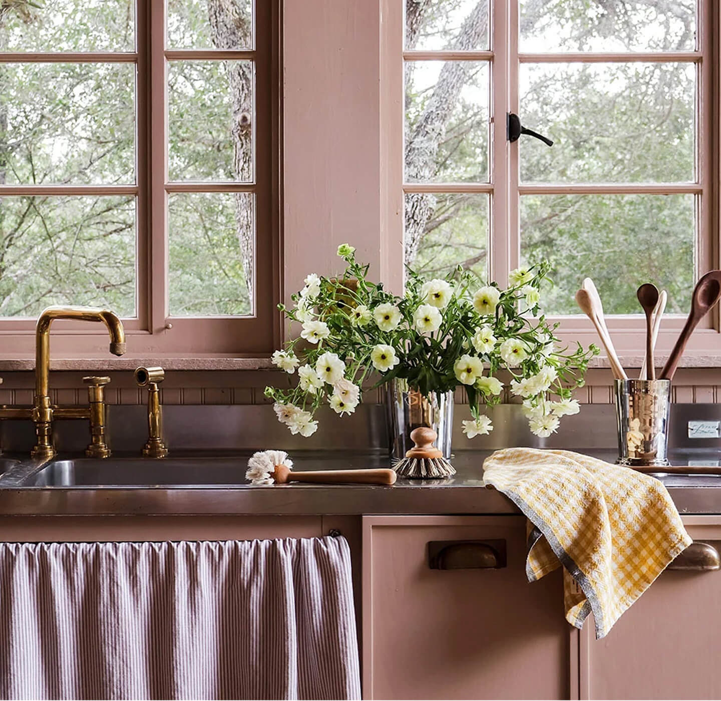 Handcrafted woven baskets with daisies on a linen-covered table outdoors